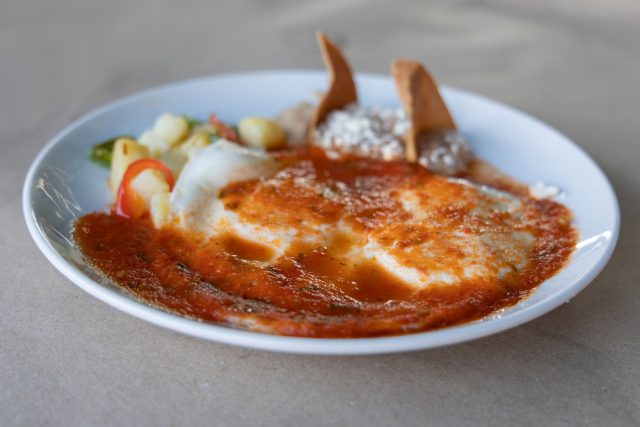 Уэвос ранчерос — мексиканский завтрак с характером: яйца на тортилье, фасоль, томатный соус, авокадо и яркие зелёные акценты. Блюдо выглядит щедро, сочно и сразу задаёт бодрое настроение.