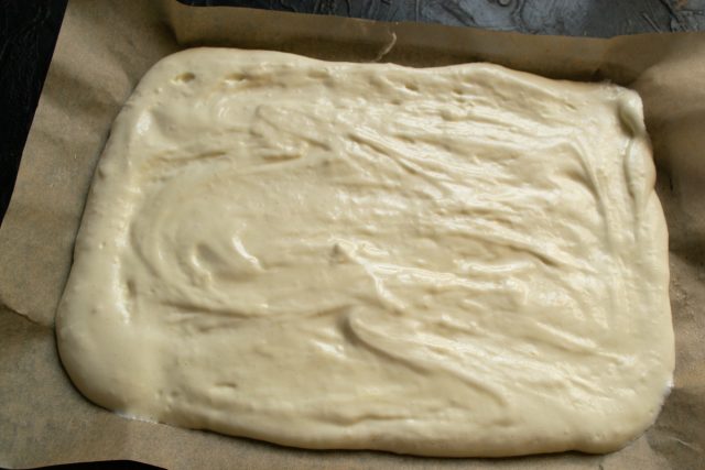 Распределение теста по противню с пергаментом