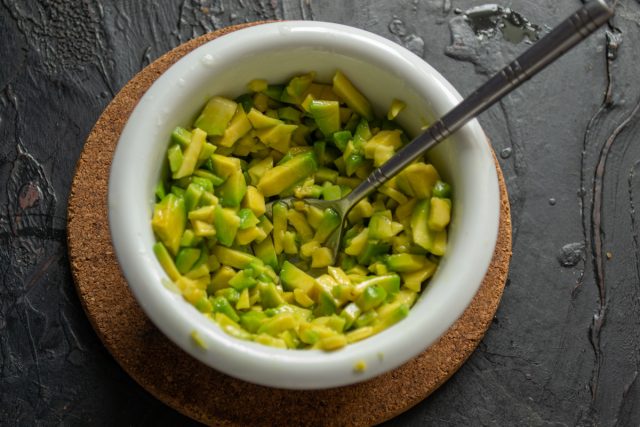 Кладем нарезанное авокадо в миску и посыпаем морской солью. Поливаем массу небольшим количеством оливкового масла первого холодного отжима сорта extra virgin.