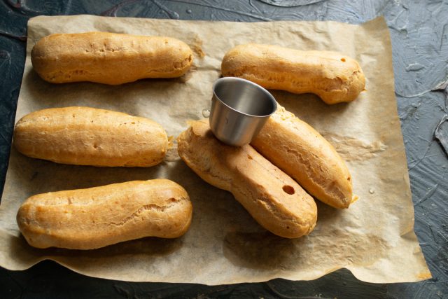 В нижней части остывших заготовок эклеров проделываются технологические отверстия для последующего введения кремовой начинки с помощью кондитерской насадки.