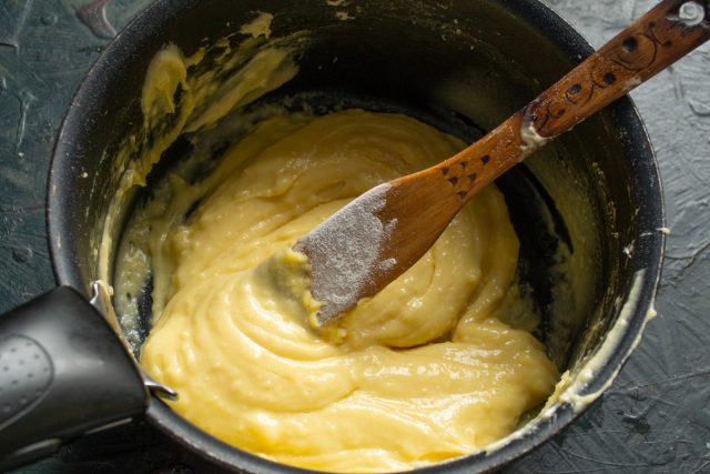 Кастрюля снимается с огня, тесто остывает до безопасной температуры, после чего в массу поочередно вводятся куриные яйца при непрерывном вымешивании венчиком.