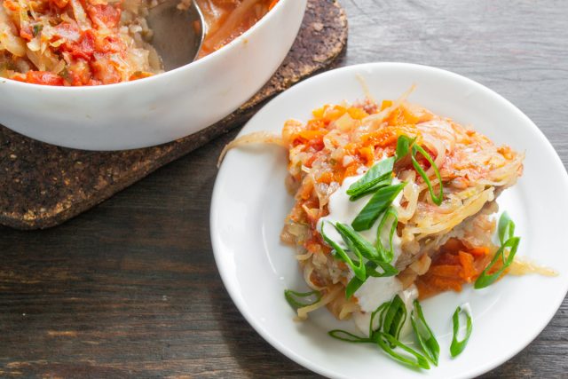 Даем готовому блюду настояться 15 минут под фольгой. Подаем ленивые голубцы горячими, дополнив каждую порцию густой сметаной и мелко нарезанным зеленым луком.