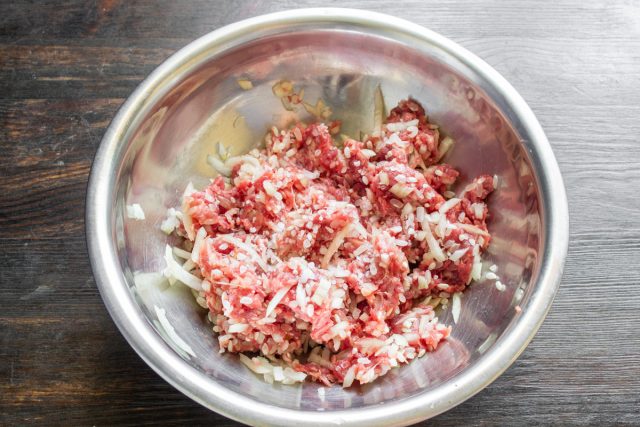 Приправляем фарш солью и черным перцем, вливаем половину стакана холодной воды. Тщательно вымешиваем массу, чтобы она стала сочной и легче пропитывалась соусом.