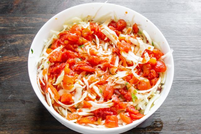 Выливаем томатный соус в форму и протыкаем слои ножом в нескольких местах. Это поможет заливке проникнуть до самого дна и равномерно пропитать рис и капусту.