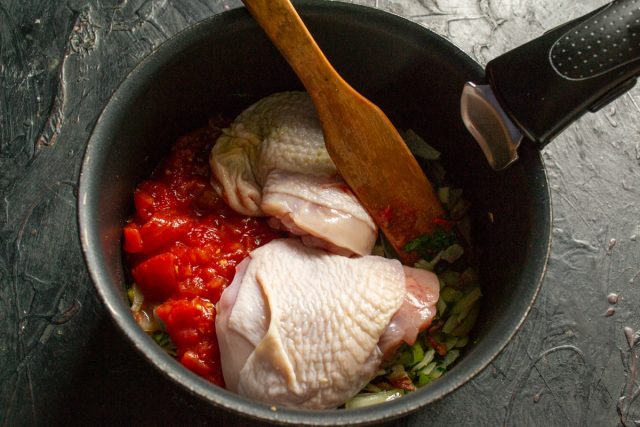 Помещаем в томатную основу целые куриные бедра. Тщательно промываем мясо перед закладкой и при необходимости удаляем излишки жира или остатки перьев.