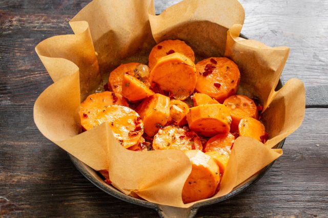 Перемешиваем содержимое сковороды и разравниваем ломтики в один слой. Поливаем заготовку растопленным сливочным маслом и посыпаем рублеными грецкими орехами. Перемешиваем содержимое сковороды и разравниваем ломтики в один слой. Поливаем заготовку растопленным сливочным маслом и посыпаем рублеными грецкими орехами.