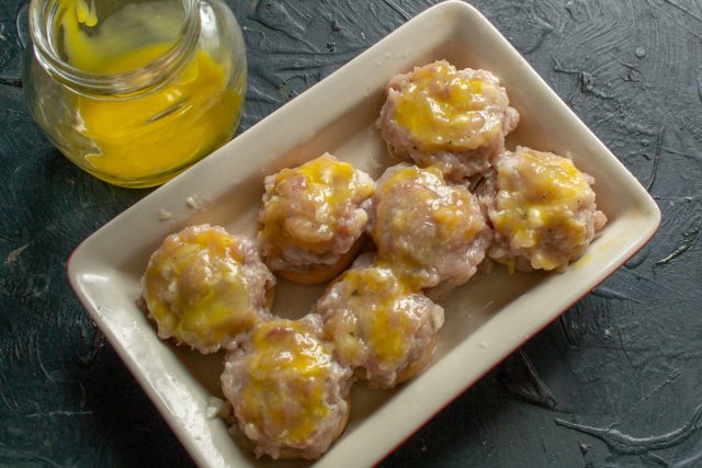 Поверхность мясных фрикаделек обрабатывается смесью яичного желтка и молока с помощью кисти для получения глянцевого блеска и аппетитного цвета. Поверхность мясных фрикаделек обрабатывается смесью яичного желтка и молока с помощью кисти для получения глянцевого блеска и аппетитного цвета.