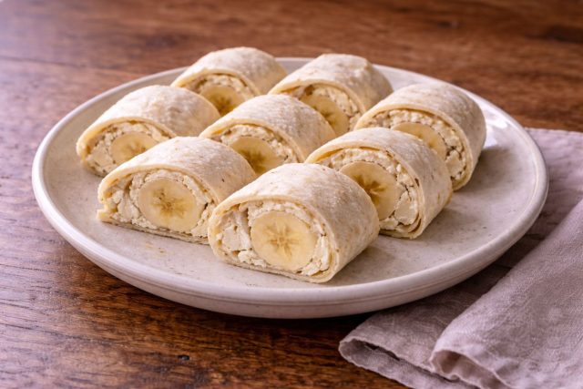 Лаваш с творожным кремом и бананом, свернутый в рулет и нарезанный кусочками. Простой десерт, который можно приготовить за несколько минут и подать к чаю.