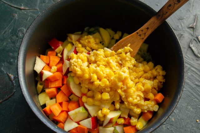 Добавление кукурузного пюре в кастрюлю с овощами