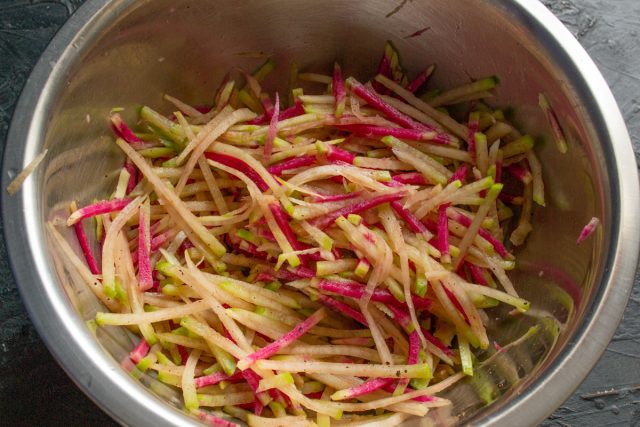 Перетирание редьки со специями руками в резиновых перчатках