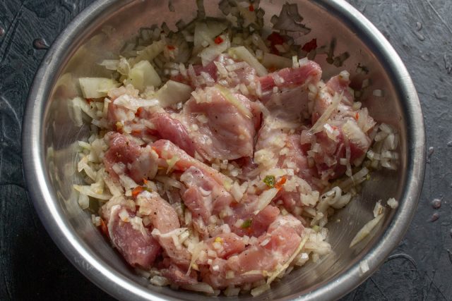 Перемешивание мяса со специями в глубокой миске