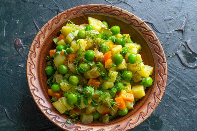 Готовый салат, посыпанный укропом и перцем