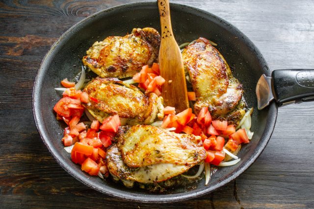 Пассерование овощей с куриным мясом Добавление кубиков томатов к полупрозрачному луку и куриным бедрам