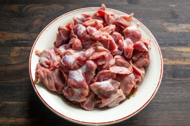 Тщательно промытые и очищенные сырые куриные желудки в миске