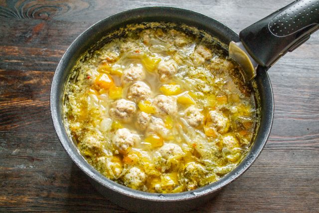Опускаем мясные фрикадельки в кипящий бульон, снова доводим до кипения, убавляем огонь до минимума, закрываем крышкой и варим блюдо около двадцати пяти минут до готовности. Опускаем мясные фрикадельки в кипящий бульон, снова доводим до кипения, убавляем огонь до минимума, закрываем крышкой и варим блюдо около двадцати пяти минут до готовности.