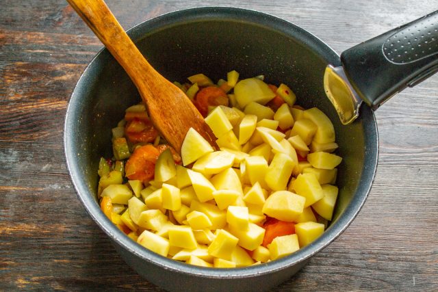Очищаем картофель от кожуры, нарезаем аккуратными кубиками размером около одного сантиметра, отправляем в кастрюлю следом за перцем и обжариваем на сильном огне пять минут. Очищаем картофель от кожуры, нарезаем аккуратными кубиками размером около одного сантиметра, отправляем в кастрюлю следом за перцем и обжариваем на сильном огне пять минут.