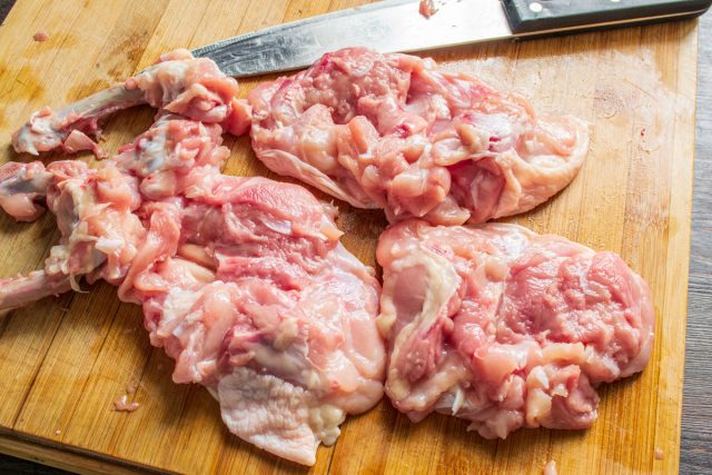 Удаление костей из куриных бедер. Куриные бедра промывают водой и аккуратно вырезают кости острым ножом.