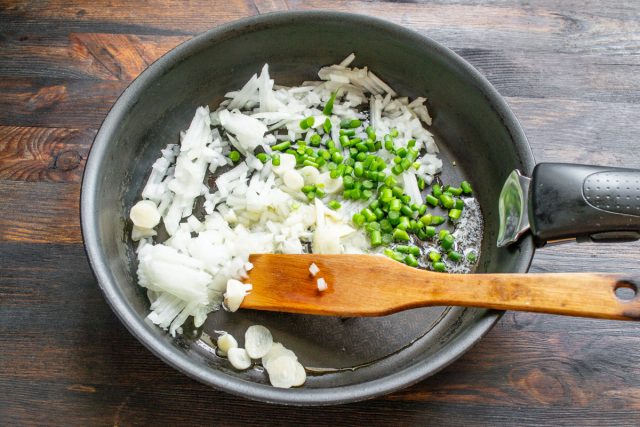 Нарезаем чеснок прозрачными ломтиками, а свежие стрелки короткими кусочками, добавляем их к луку в сковороду, солим и тщательно готовим до идеальной мягкости. Нарезаем чеснок прозрачными ломтиками, а свежие стрелки короткими кусочками, добавляем их к луку в сковороду, солим и тщательно готовим до идеальной мягкости.