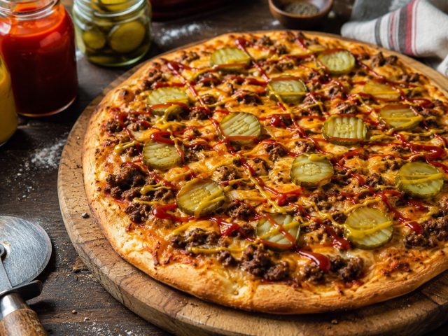 Вкус чизбургера легко переносится на пиццу: обжаренный говяжий фарш, чеддер, маринованные огурчики, кетчуп и горчица. Получается сочная начинка с узнаваемым фастфудным характером. Вкус чизбургера легко переносится на пиццу: обжаренный говяжий фарш, чеддер, маринованные огурчики, кетчуп и горчица. Получается сочная начинка с узнаваемым фастфудным характером.