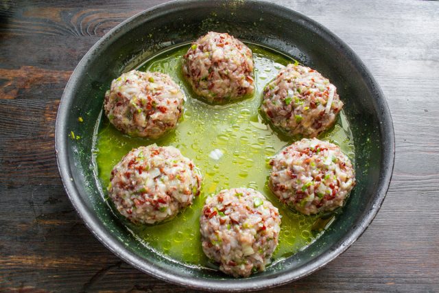 Осторожно перекладываем круглые мясные шарики в глубокую сковородку с толстым дном и заливаем их горячим наваристым куриным бульоном со всеми нужными приправами.