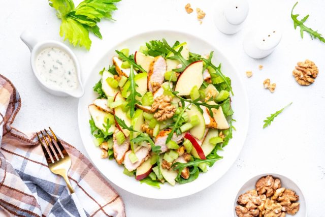 Остывшую курицу смешивают с яблоком, сельдереем, листьями салата и орехами, а вместо майонеза используют йогуртовую заправку с горчицей и лимоном. Фото: Adobe Stock / 5ph