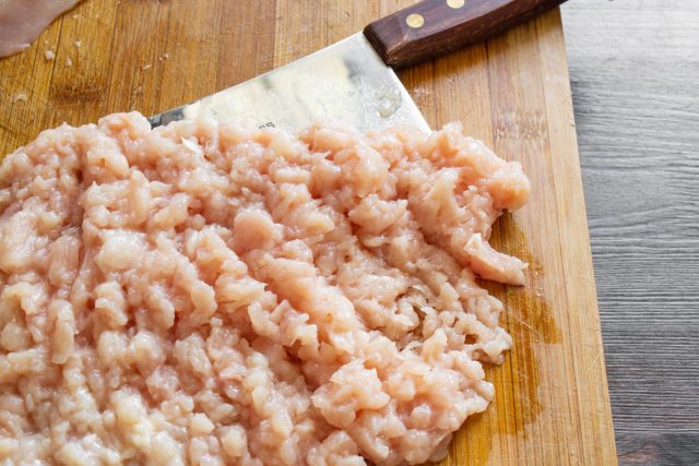Берем большой острый нож или мясной топорик и нарезаем охлажденное филе куриной грудки на разделочной доске аккуратными мелкими кубиками, чтобы приготовить сочную котлету.